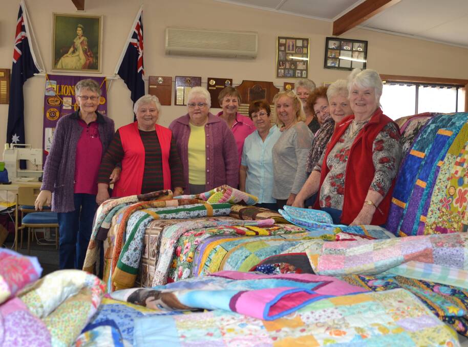 Winter warmth: The Mandurah Sew'n'So's with some of the 40 quilts they handmade for Yarloop's bushfire victims who lost everything. Photo: Nathan Hondros.