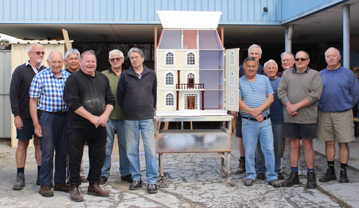 Finishing touches: Members of Mandurah Men’s Shed work on a special doll house that’s up for grabs at this year’s event. Photo: Supplied.