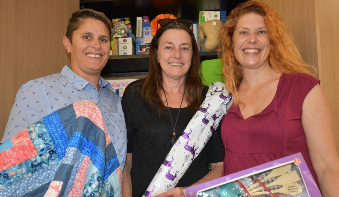 Wanslea foster care workers: Senior social worker Kay Symes and family support workers Lisa Martin and Kate Lamers with Christmas presents donated by local agencies for children in care. Photo: Carla Hildebrandt. 