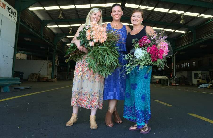 Coming up roses: Florists Jade McIntosh, left, and Kim Stenhouse, right, with Jessica Eckford-Aguilera. Picture: Penelope Green
