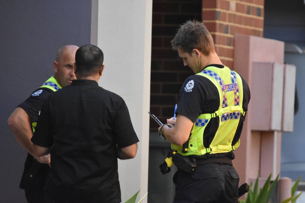 Police speaking to a neighbour at the scene. Photo: Caitlyn Rintoul.