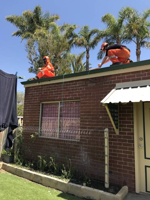 Members of Mandurah SES placing tarp over a broken shed roof this morning. Photo: Bec Burns/Mandurah SES unit media officer.   