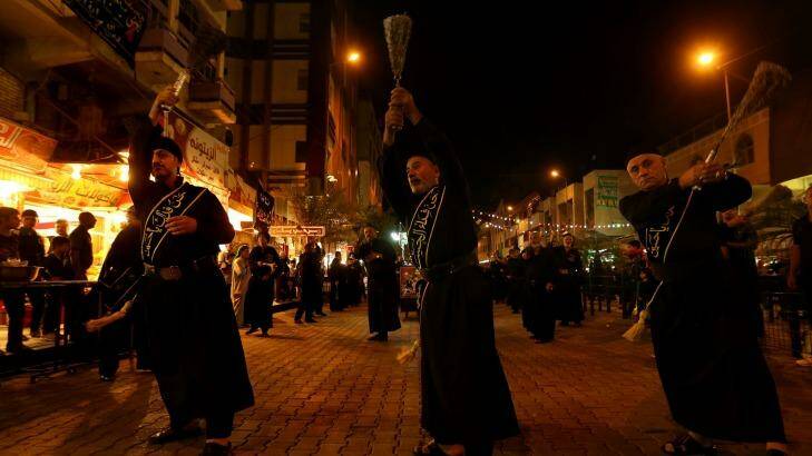 Shiite Muslim men beat themselves with chains during the Ashura procession. Photo: Kate Geragty