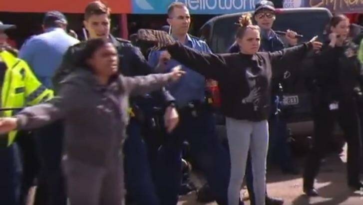 Ms Garlett is joined by her mother between rioters and police in Kalgoorlie. Photo: 9 News Perth