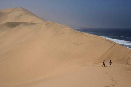 I had the chance to visit Namibia from South Africa. A four wheel drive, up, over and down immense sand dunes was both scary and exciting.

This picture of two people in the dunes helps one realise both how big the dunes are, as well as their proximity of the Atlantic Ocean. Photo: Peter Conroy