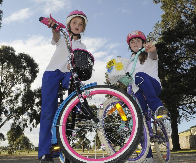 TERRIFIED: Students Ellie Palmer, 8, and Sarah Ryan, 9, say they are scared to ride their bikes to school after numerous attacks by a swooping magpie. Photo: CHRIS SEABROOK  091514cmaggies1