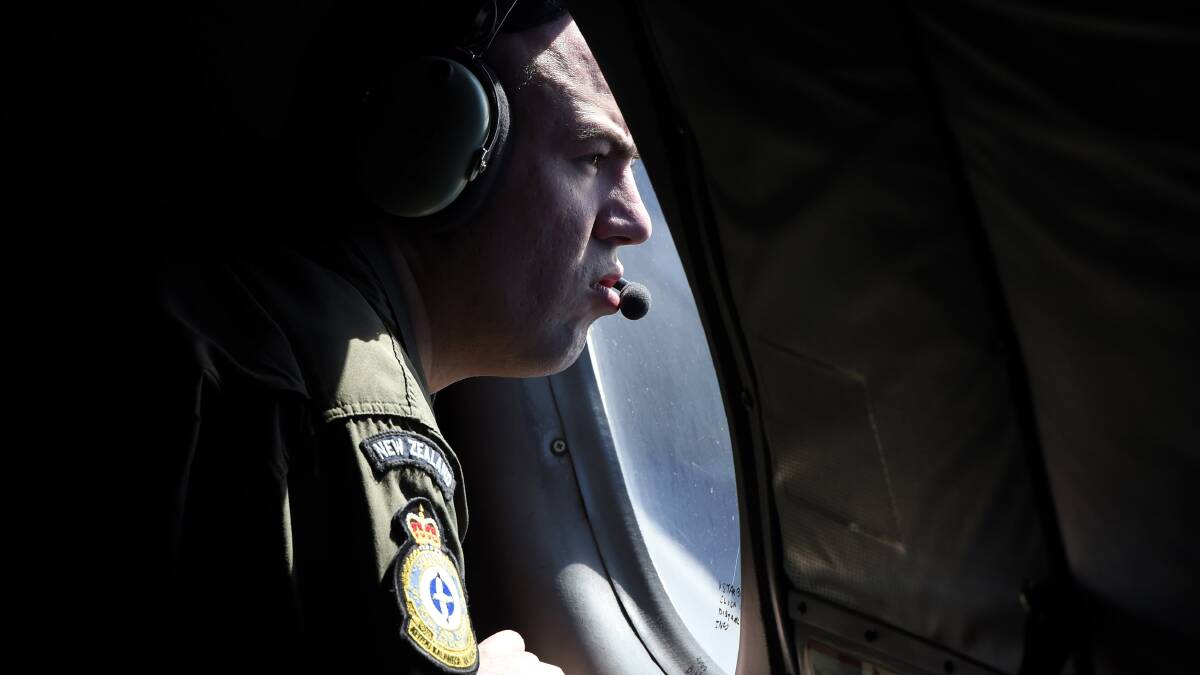 A crew member looks out an observation window aboard a Royal New Zealand Air Force (RNZAF) P3 Orion maratime search aircraft as it flies over the southern Indian Ocean looking for debris from missing Malaysian Airlines flight MH370 on April 11. Photo: Richard Polden/Getty Images.