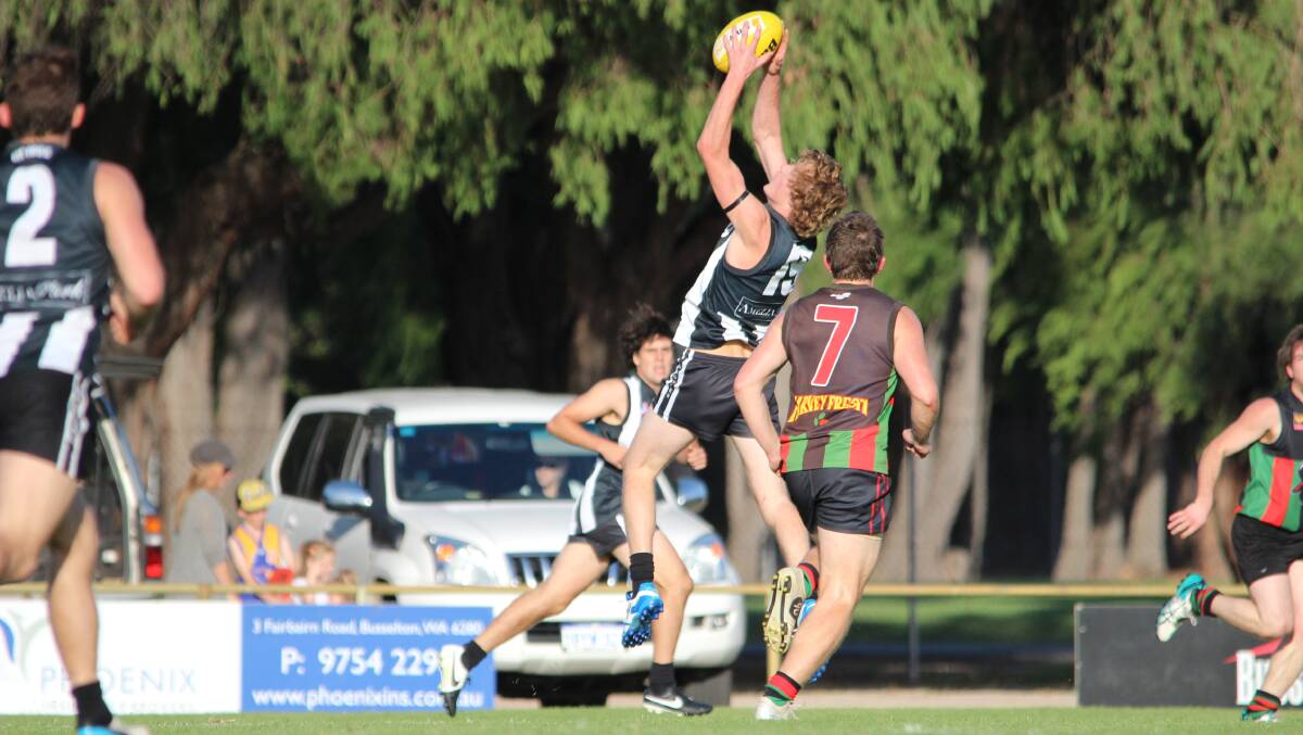 Busselton Football Club player Zak Austin  going up for the mark.