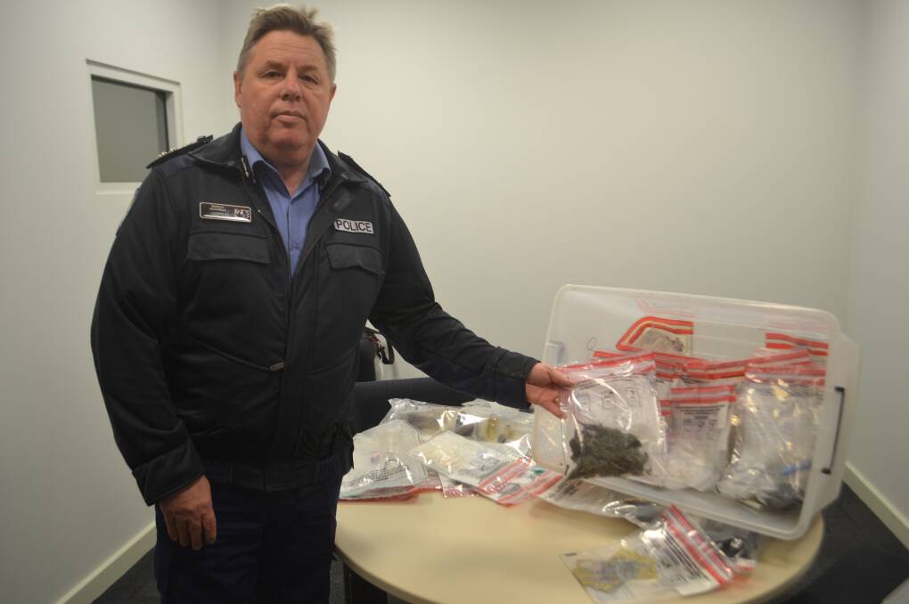 State commander for leavers Murray Smalpage with the seized prohibited drugs, paraphernalia and cash. 