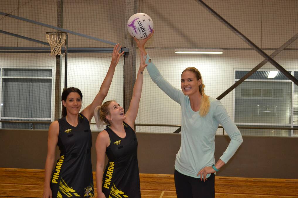 Tall order: Jenna Daniels and Krystal Lema reach for the ball held by West Coast Fever star Caitlin Bassett.