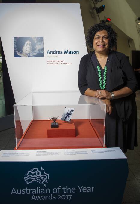 Northern Territory Indigenous leader and Australian of the Year finalist Andrea Mason with her family portrait and the sports trophy she won in 1972. Photo: Elesa Kurtz
