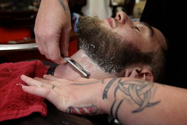 An old style shave with a cut throat razor by Sasha Coxon, from Chops 'N Charlies Barbers in Sydney. Photo Danielle Smith