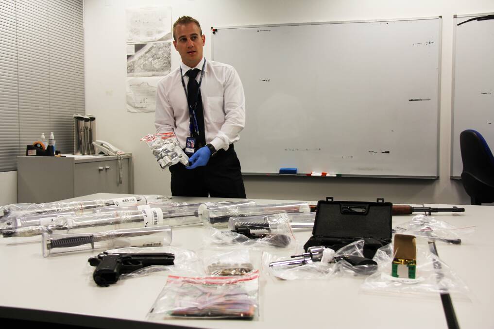 Detective First Class Dan Cochrane with replica weapons seized from a property in Baldivis yesterday.   Picture: Elisia Seeber/Sound Telegraph