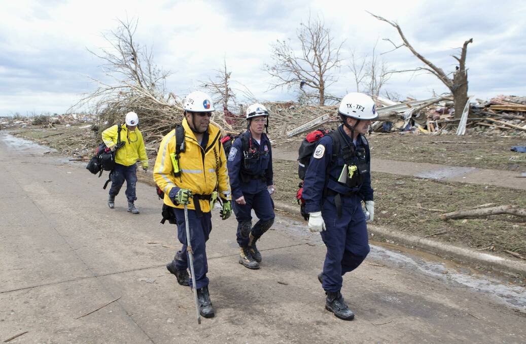 Recovery workers walk through the destruction in a neighborhood in Moore, Oklahoma May 21, 2013. Photo: REUTERS/Richard Rowe