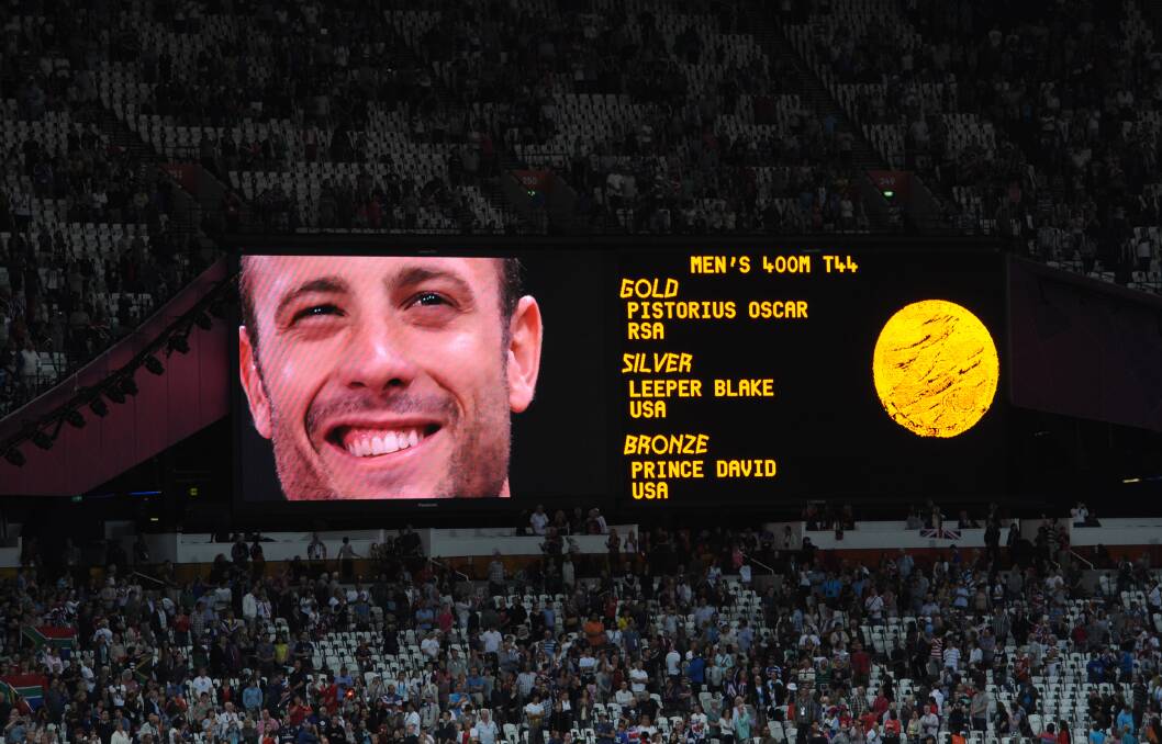 Oscar Pistorius observes his national anthem on the big screen after receiving his Gold medal for the Men's 400m - T44 on Day 10 of the London 2012 Paralympics. Photo by Stefan Rousseau - WPA Pool/Getty Images