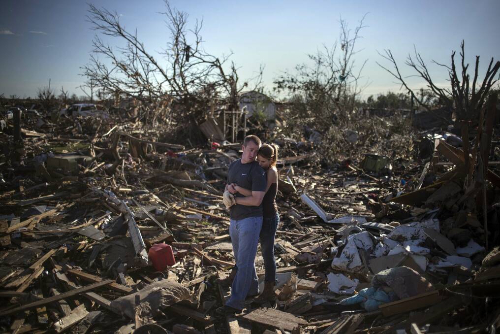 Danielle Stephan holds boyfriend Thomas Layton as they pause between salvaging through the remains of a family member's home one day after a tornado devastated the town Moore, Oklahoma, in the outskirts of Oklahoma City May 21, 2013. Photo: REUTERS/Adrees Latif