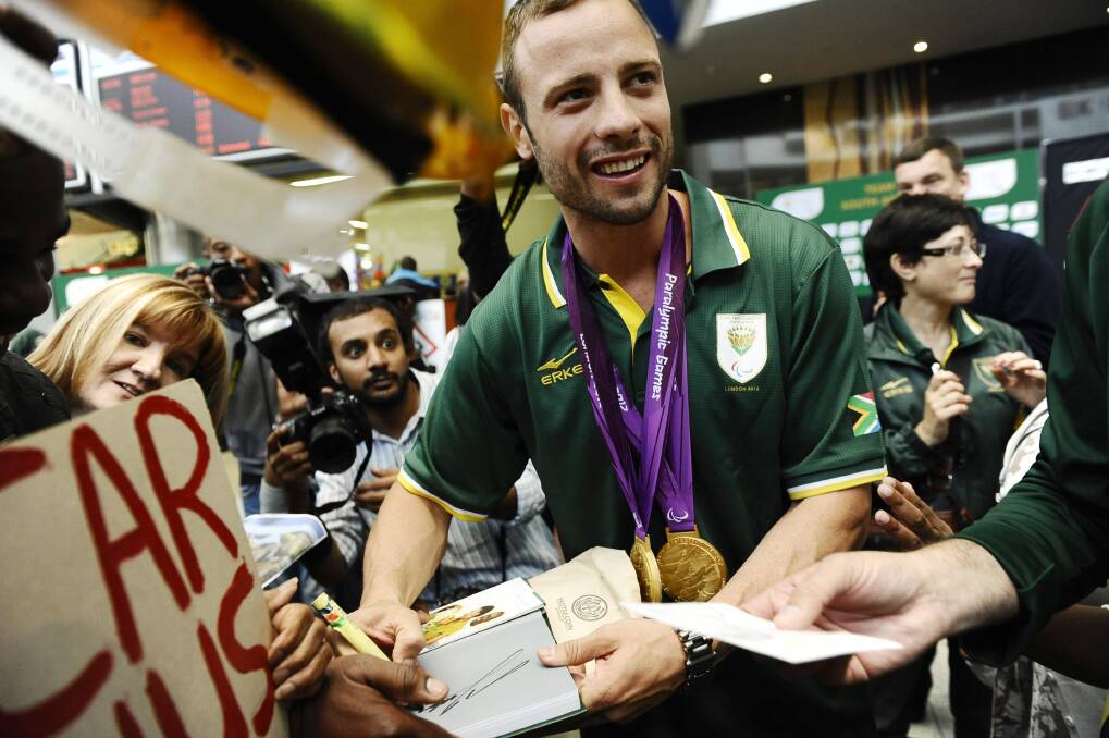 Oscar Pistorius meets fans and signs autographs during the South African Paralympic team arrival at O.R Tambo International Airport. Photo by Lefty Shivambu/Gallo Images/Getty Images