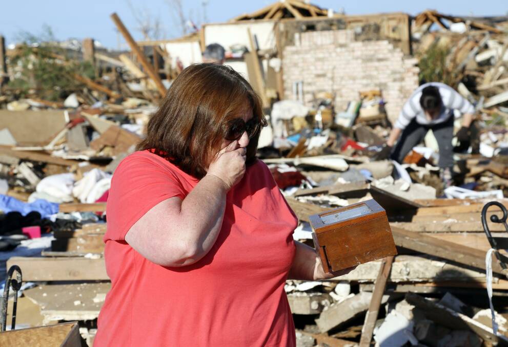 Kelli Kannady weeps after finding a box of photographs of her late husband in the rubble near what was her home in Moore, Oklahoma May 21, 2013. Photo: REUTERS/Rick Wilking 