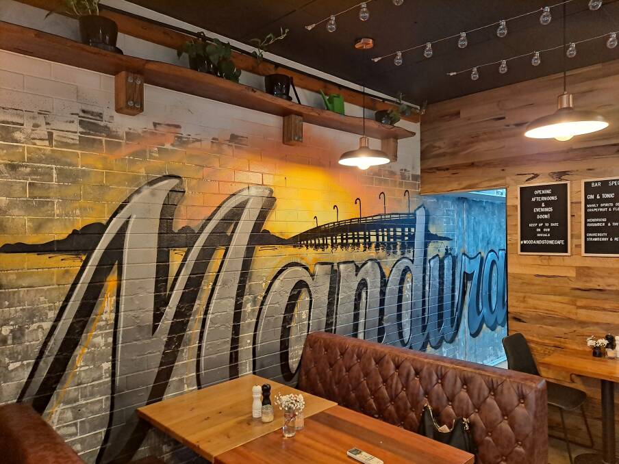 DECOR: Graffiti mural portraying the old bridge scenery behind the word 'Mandurah,' is a feature wall piece at Wood and Stone. Photo: Supplied.