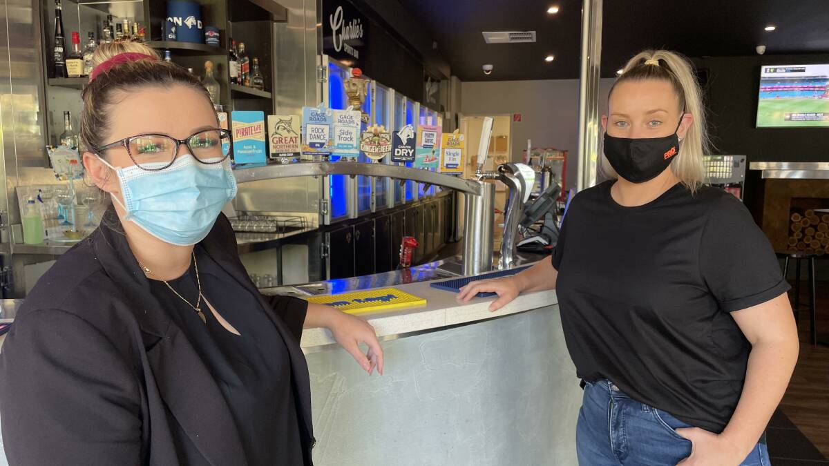 New normal: Brittney Hutchen-Craig and Courtney Palmer from Brighton hotel are doing their jobs and keeping people safe. Picture: Brianna Melville. 