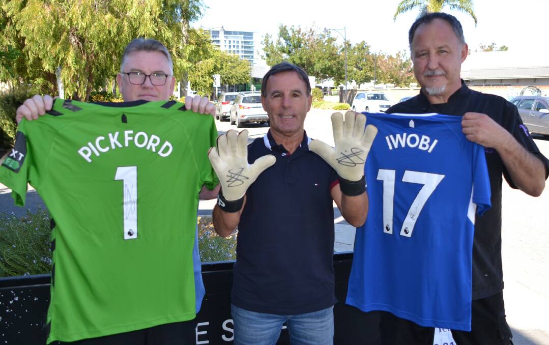 Citrus Marketing & Promotions' Jon Ring and Les Rimmer with Tree of Life Cafe chef Dave Hills, who is providing food for the event, with some of the signed items to be auctioned off including Everton and England goalkeeper Jordan Pickford's signed shirt and gloves, and a signed Alex Iwobi shirt. Picture by Stuart Horton.
