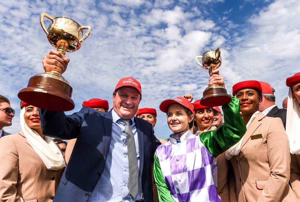 Darren Weir holding the 2015 Melbourne Cup aloft, alongside Ballarat's Michelle Payne.