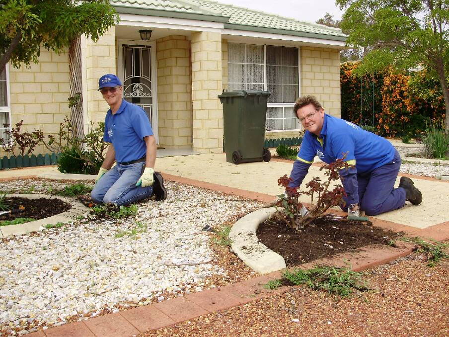 Time's up: Gardening volunteers Peter Manwaring and Bruce Raymond working on a property in Mandurah. Photo: Supplied.