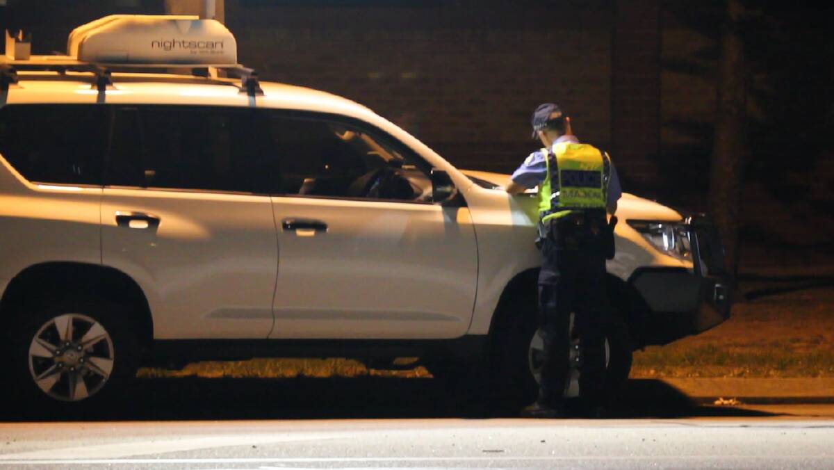 A Major Crash officer collecting evidence at the scene along Old Coast Road on Saturday evening. Photo: Caitlyn Rintoul.