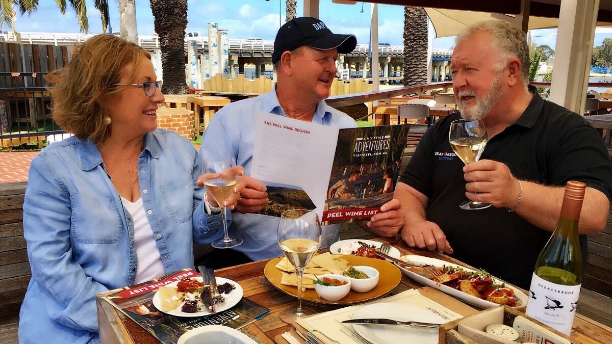Bottoms up: Peel Wine Association president Bernie Worthington (right) briefs visitors Jennifer and Malcolm King on the new Peel Wine Menu at The Heritage.