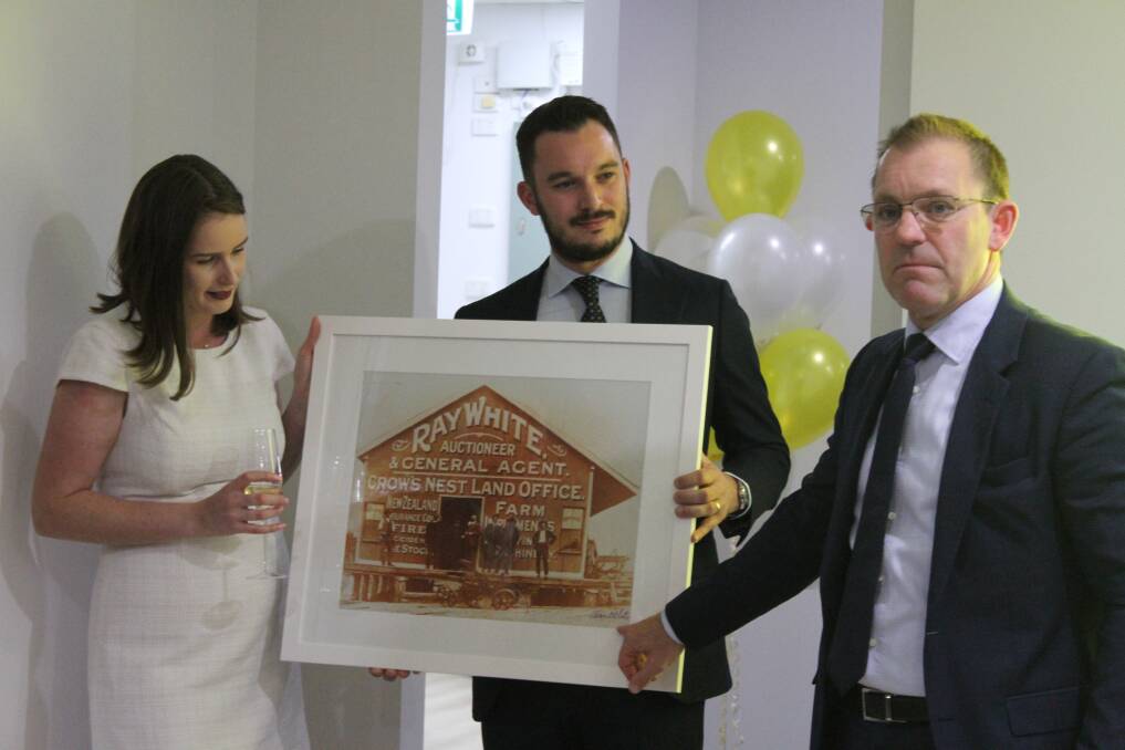 Ray White WA chief executive Mark Whiteman presenting a photo of the original Ray White office to Emma and Theo Alexandrou. Picture: Claire Sadler.