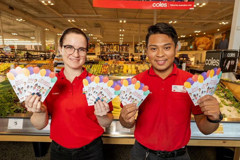 Coles team member Ahlee and John with $2 donation cards, which will support children's hospitals across the country. Photo: Supplied.