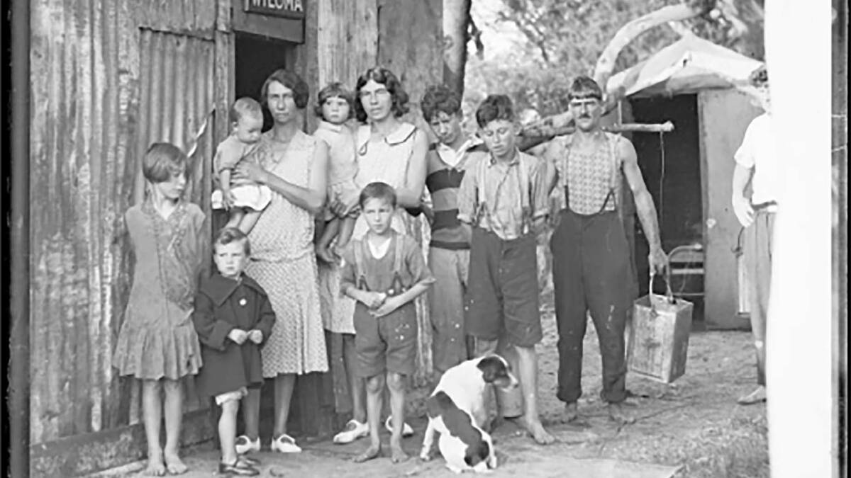 An Australian family standing outside a tin shack during the Great Depression. Picture: National Library of Australia.