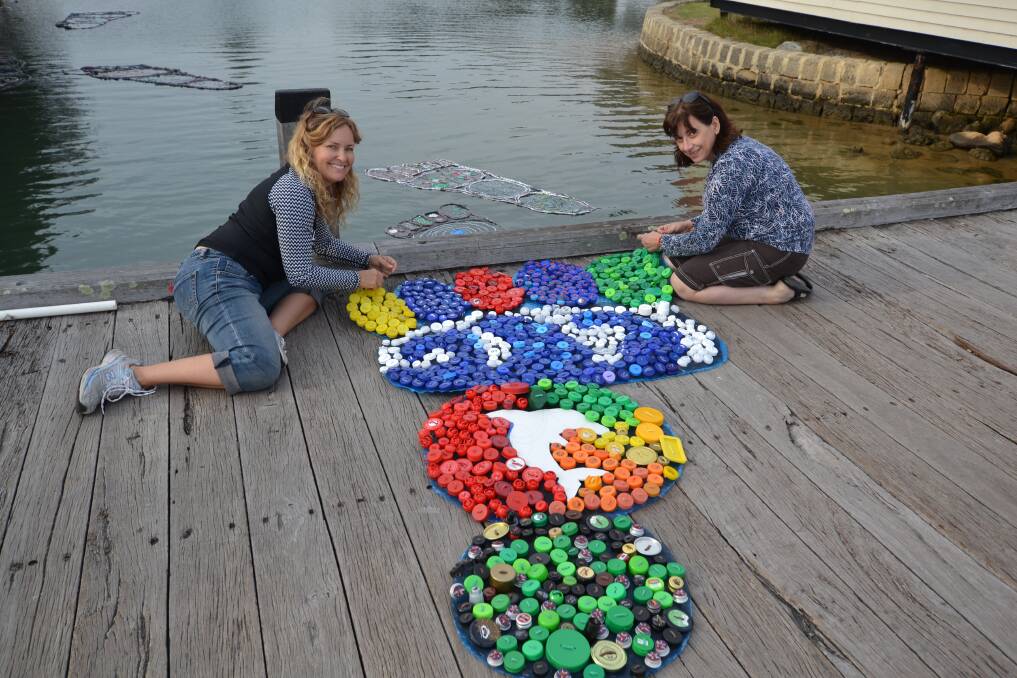 Put a lid on it: Visual artist Jodie Davidson and art teacher Sue Girak with one of the bottle top footprints. Photo: Amy Martin.