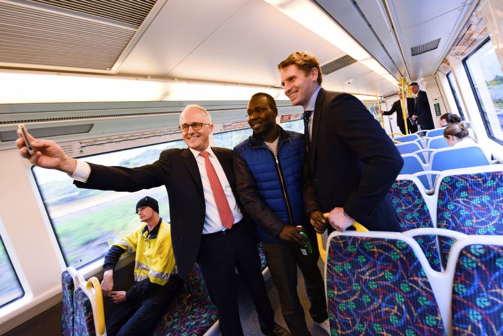 Mandurah bound: Prime Minister Malcolm Turnbull and Canning MP Andrew Hastie take a selfie with a passenger on the Mandurah line before passing the site of the long-awaited Lakelands station. Photo: Marta Pascual Juanola.