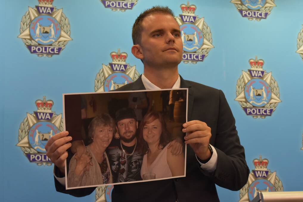 Detective First Class Constable Geoff Hawley with a photo of Daniel Lloyd and his family. Photo: Kaylee Meerton.