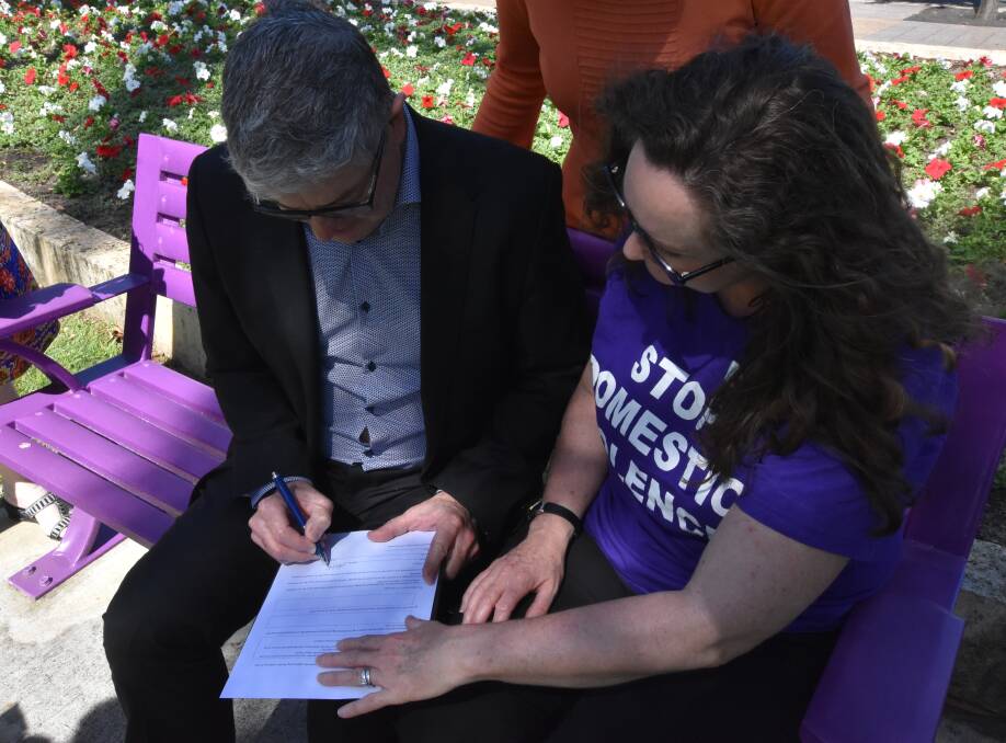 City of Mandurah chief executive Mark Newman signs the pledge with Peel Says No To Violence chairperson Nicole Lambert. Photo: Kaylee Meerton.