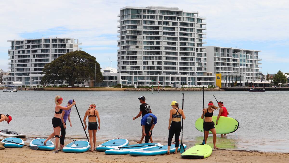 The Mandurah Magic women hit the water for a stand-up paddle session at their pre-season camp. Photo: Mandurah Surf Lessons/Star Surf.

