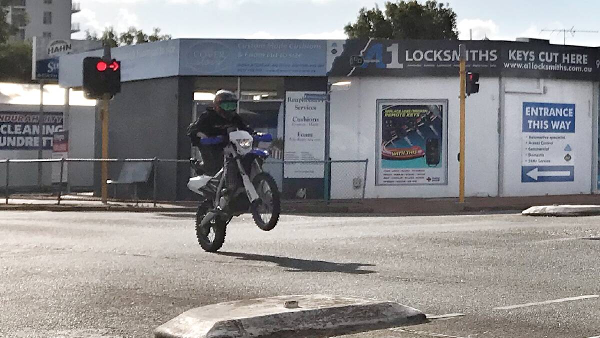 A dirt bike races through a red light on the intersection of Pinjarra Road and Sutton Street. Photo: Supplied.