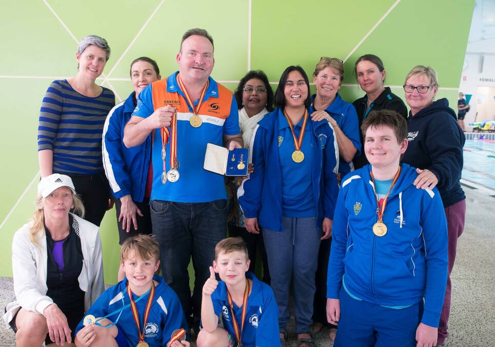 Josh Hofer shows off his medals to members of the Manta Rays Swimming Club. Photo: Mandurah Photography Club. 