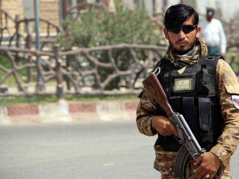 An Afghan security official on guard in Lashkar Gah which looks set to fall to the Taliban.