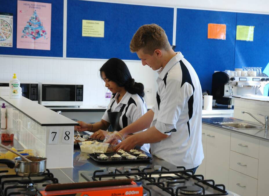 YES CHEF: Year 11 students Charlotte Estrella and Kyle Saunders catering for school guests at a morning tea in December. Photo: Adrian Toh