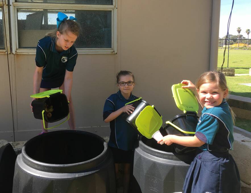 HELPING HAND: Ocean Road Primary School students Summa Leach, Sophia Dawe and Sienna Stubenrauch emptying the caddies into the compost as part of the school's Waste Wise Program. Photo: Supplied