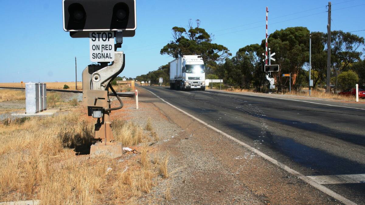 Fatal crossing: A truck passes the spot where a B double slammed into the back of a stationary Holden Commodore on Great Eastern Highway. The paint dots show where the wreckage was pushed through the crossing and off the highway.
