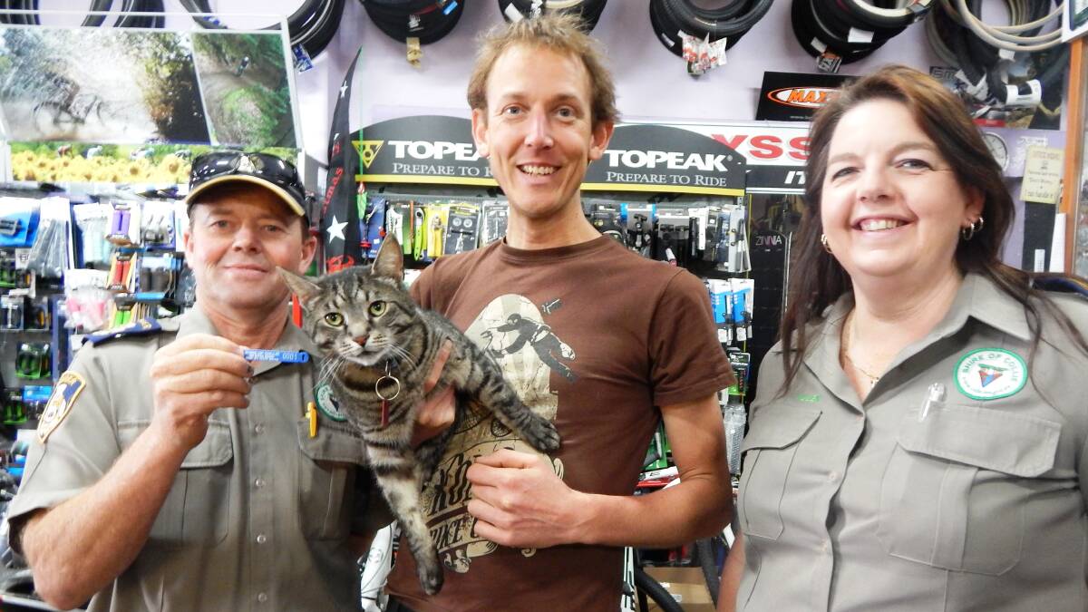 Rangers Leigh O'Connor and Helen Bryant help Erik Mellegers register his cat Sprocket. Photo: Collie Mail.