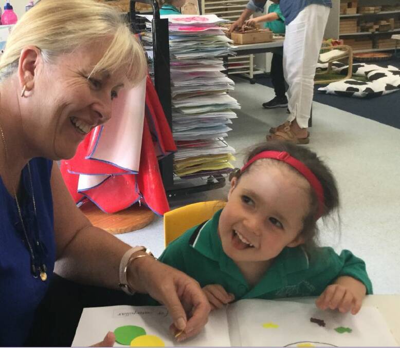 Loving learning: Special needs assistant Michelle McNamara, aka Mrs Mac, has fun in the classroom with Piper Edwards. Photo: Supplied.