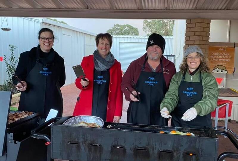 Cooking up a storm: Assistant principal Vanessa Dicker, principal Miranda Swann, Year 6 teacher Peter Allan and Genni McCormack from finance braving the cold morning to fire up the barbecue. Photo: Supplied. 