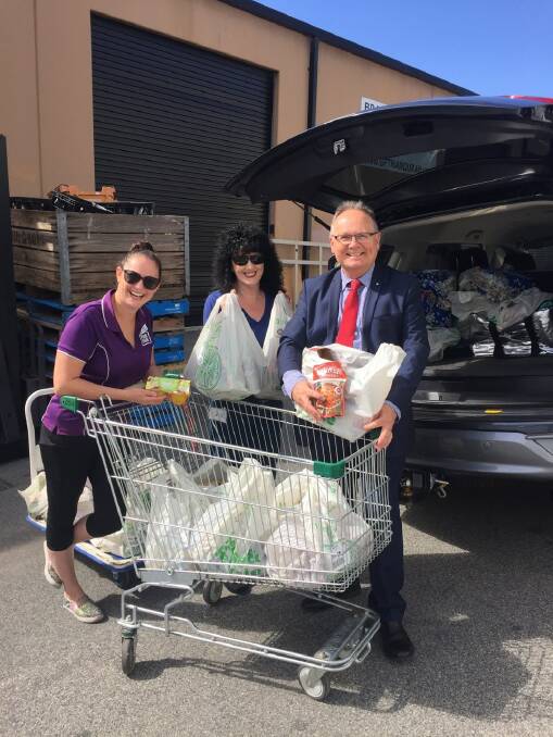 Helping hand: Megan Reynolds of Peel Foodbank accepting the generous donation from Carole Dhu and David Templeman MLA. Photo: Supplied.