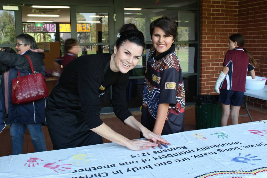 Display of unity: Mrs Shane van Rensburg and college student Jayvin Cooper with the unity mural they created for the NAIDOC Community Open Day. Photo: Supplied.